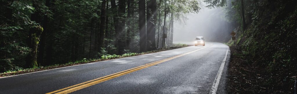 Bilden visar en bil som kör på en skogsväg. LEDbar bil och ekstralys bil ger dig bättre belysning i skymning och mörker. LED bar till bil och LED extraljus finns online hos exempelvis Ekstralyskongen.no.